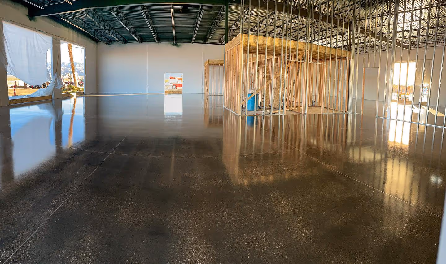Polished concrete floor in a large open commercial space reflecting the ceiling structure