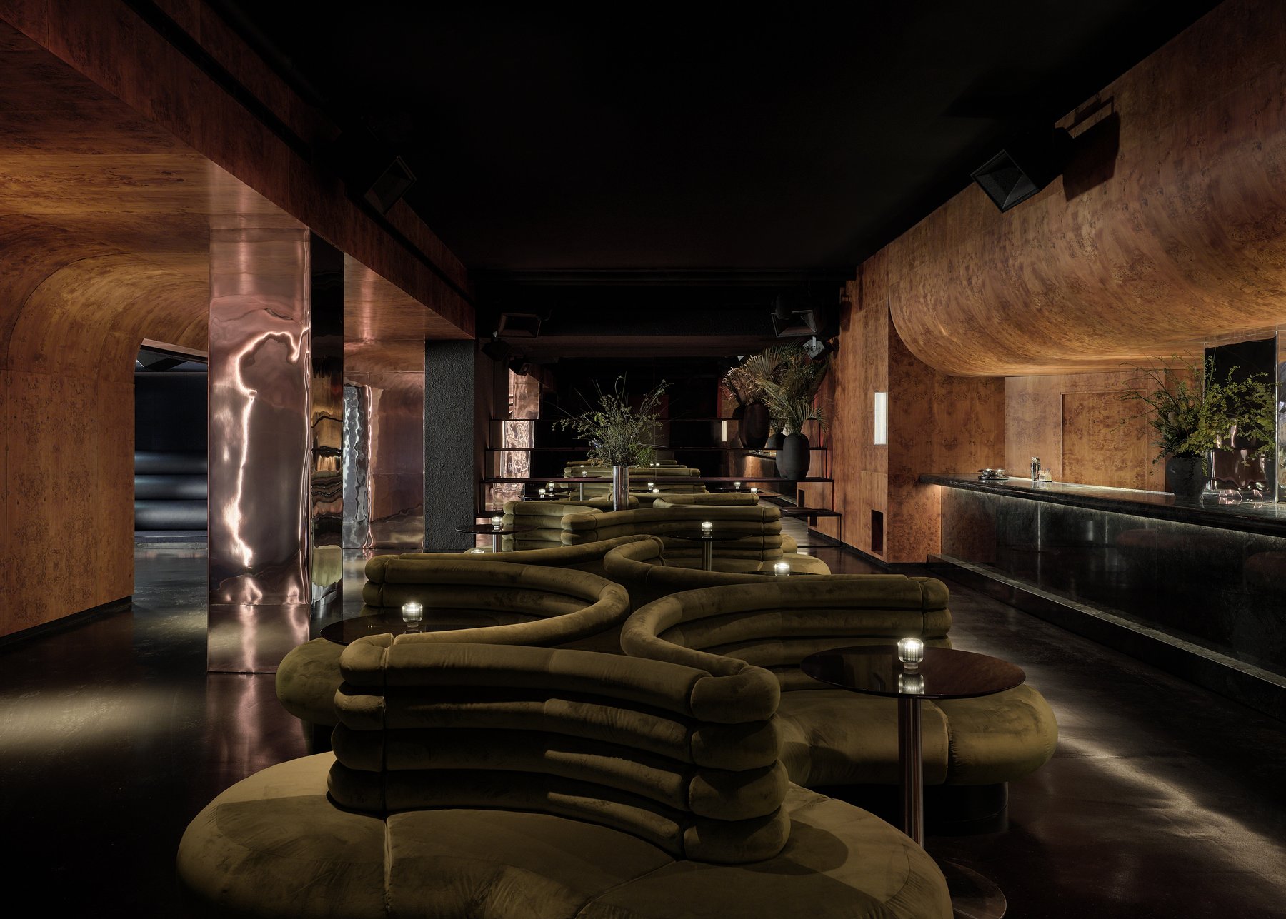 Warm-toned interior of Unveiled in Williamsburg with sculptural seating and bar