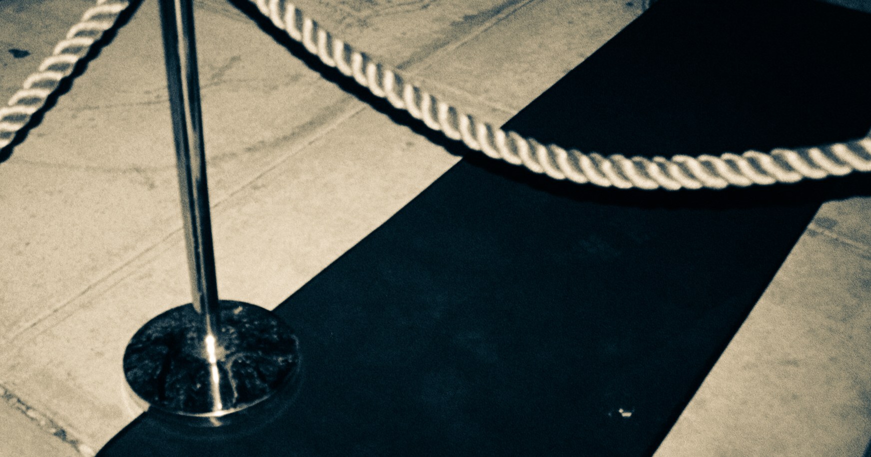 Rope and stanchion marking an organized guest-entry path at Unveiled.