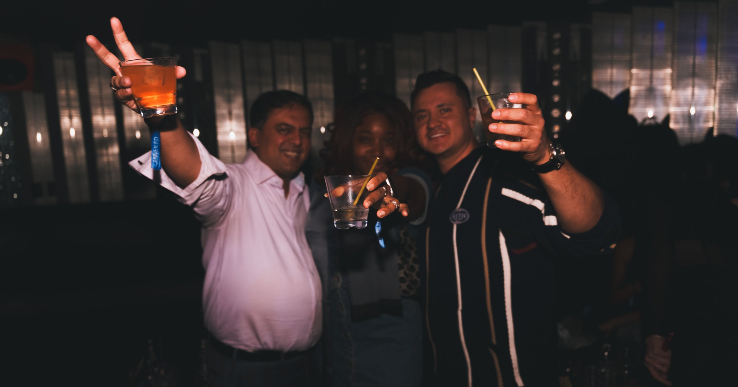 Guests raising drinks together inside the Unveiled lounge.