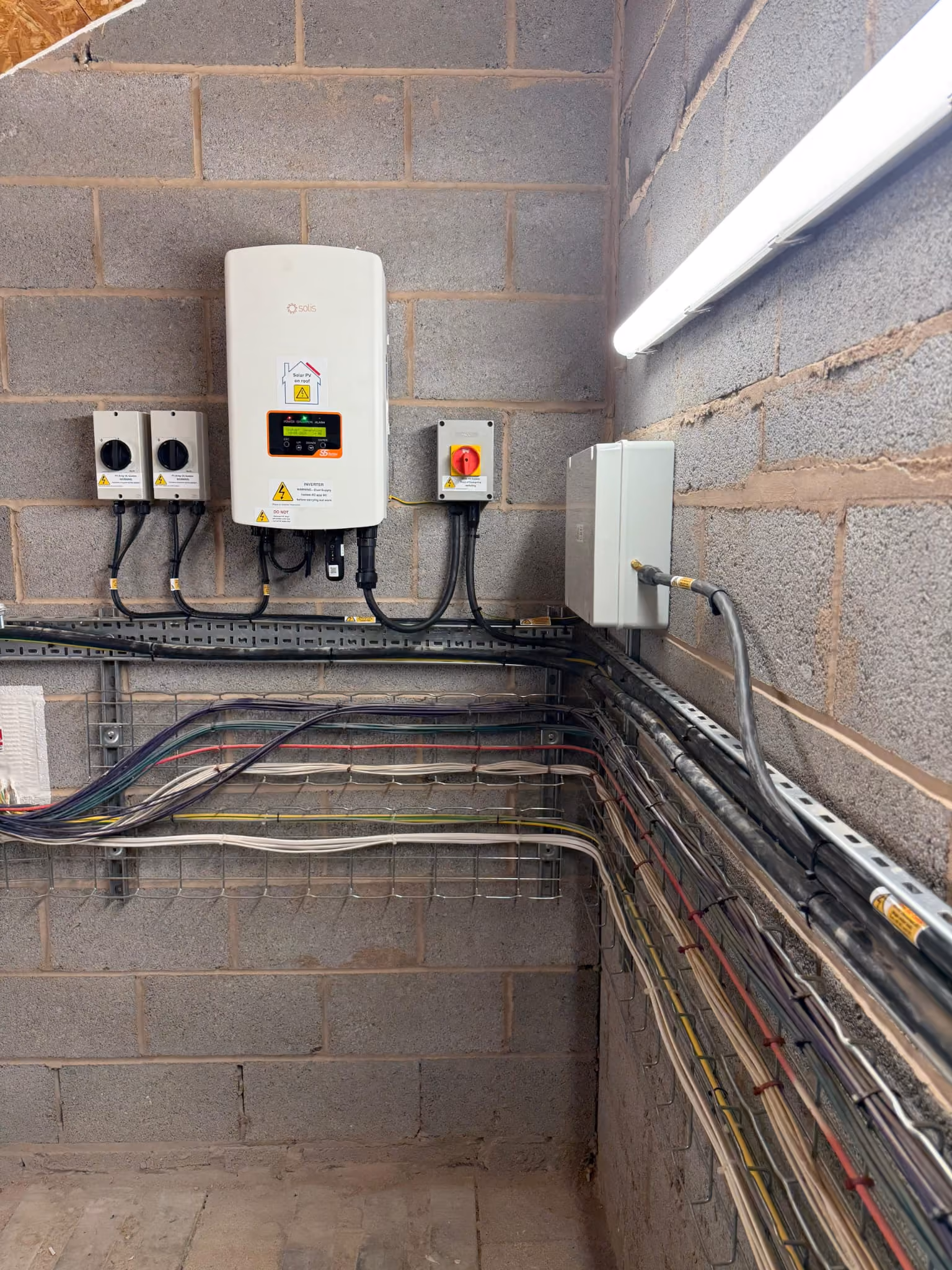 Solar PV inverter and isolator switches installed on a plant room wall