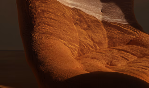 Close-up of an orange cushioned chair with soft fabric texture under warm light.