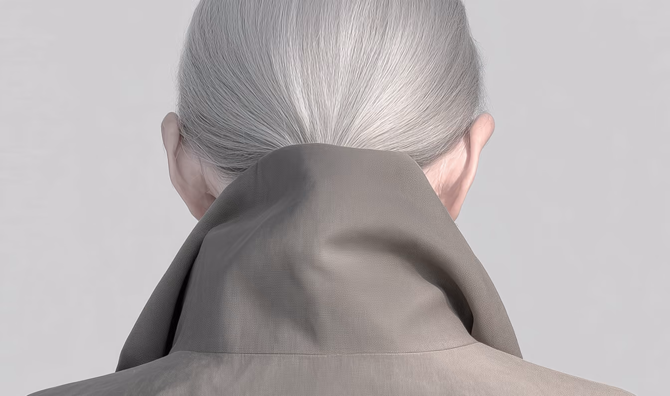 Back view of person with gray hair in a high-collared taupe jacket against a plain gray background.