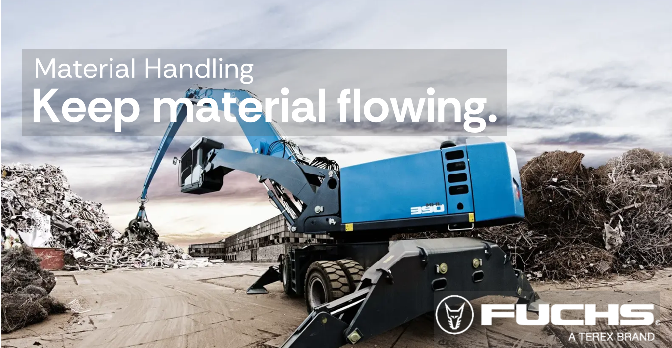 Blue Fuchs material handling machine with a claw arm picking up scrap metal in an industrial yard.