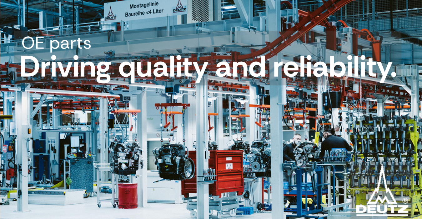 Modern assembly line in a factory with engines suspended and workers assembling parts under red overhead conveyor system.