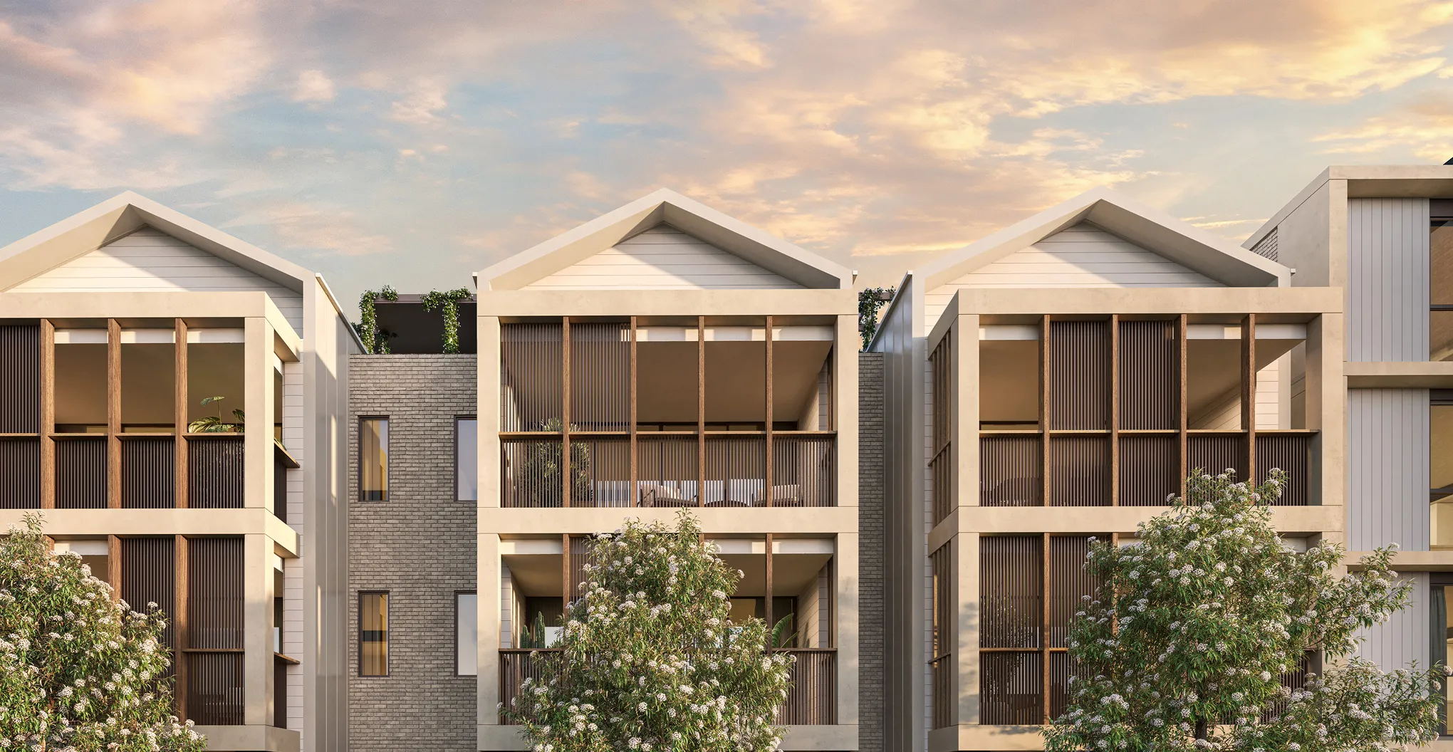 Modern townhouses with large wooden vertical slats on balconies and flowering trees in front.