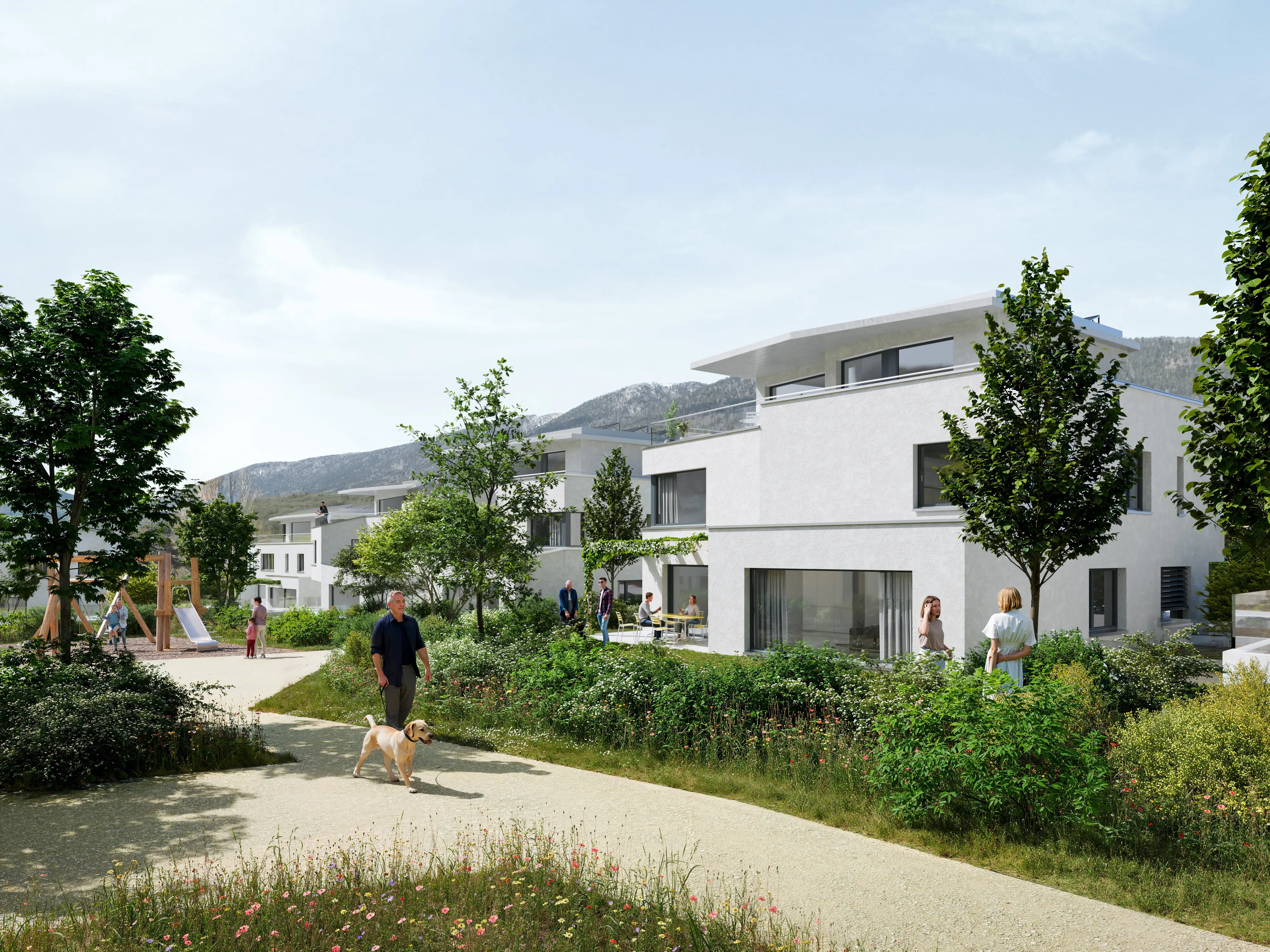 Ensemble résidentiel moderne avec chemin, espaces verts et personnes se promenant et jouant, avec montagnes en arrière-plan.