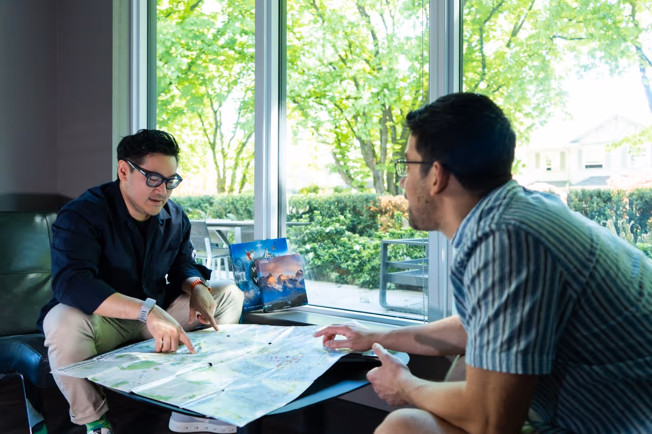 Hand pointing at a travel map with a camera nearby, representing the start of a bespoke journey with Travel Designer Vancouver