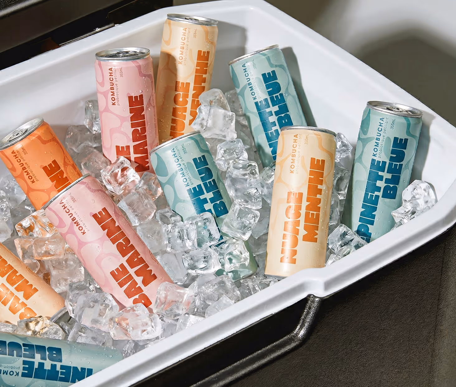 Image generated by Adobe firefly - Assorted colorful cans of kombucha drinks chilled on ice in a white cooler.