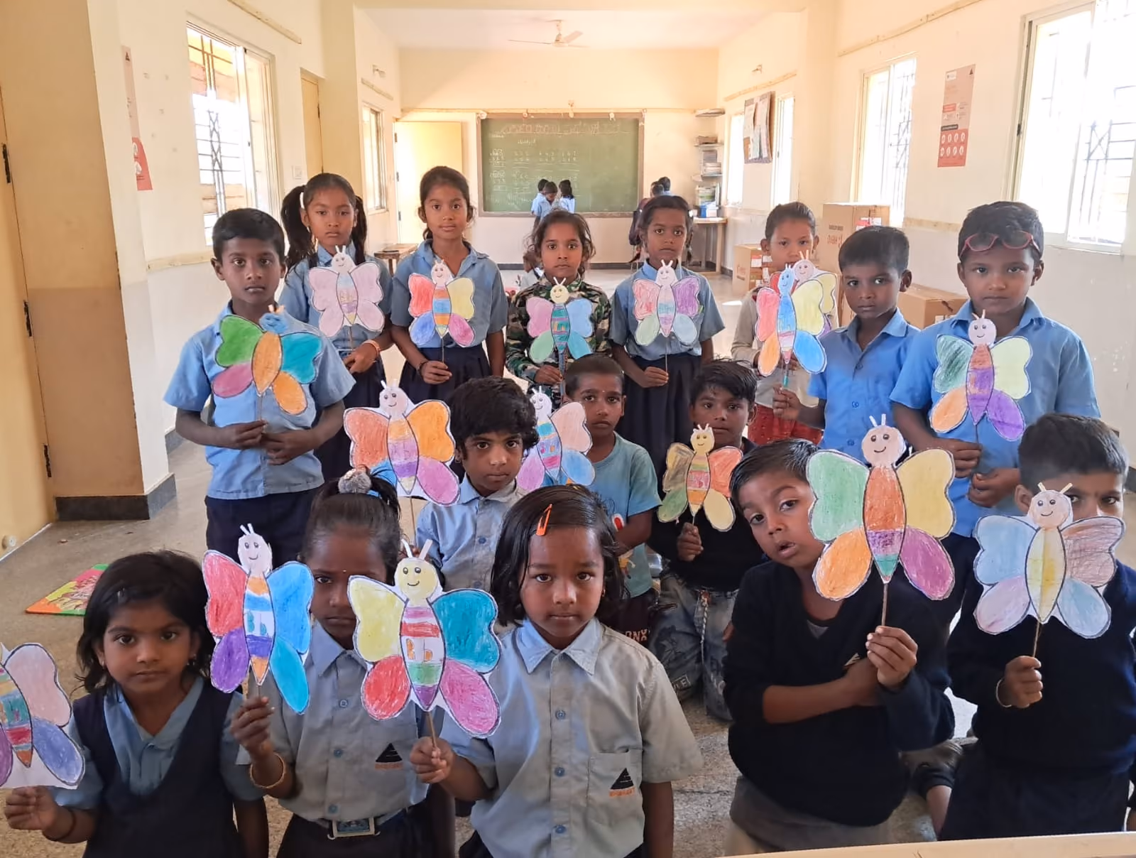 Students displaying handmade art and craft projects in class