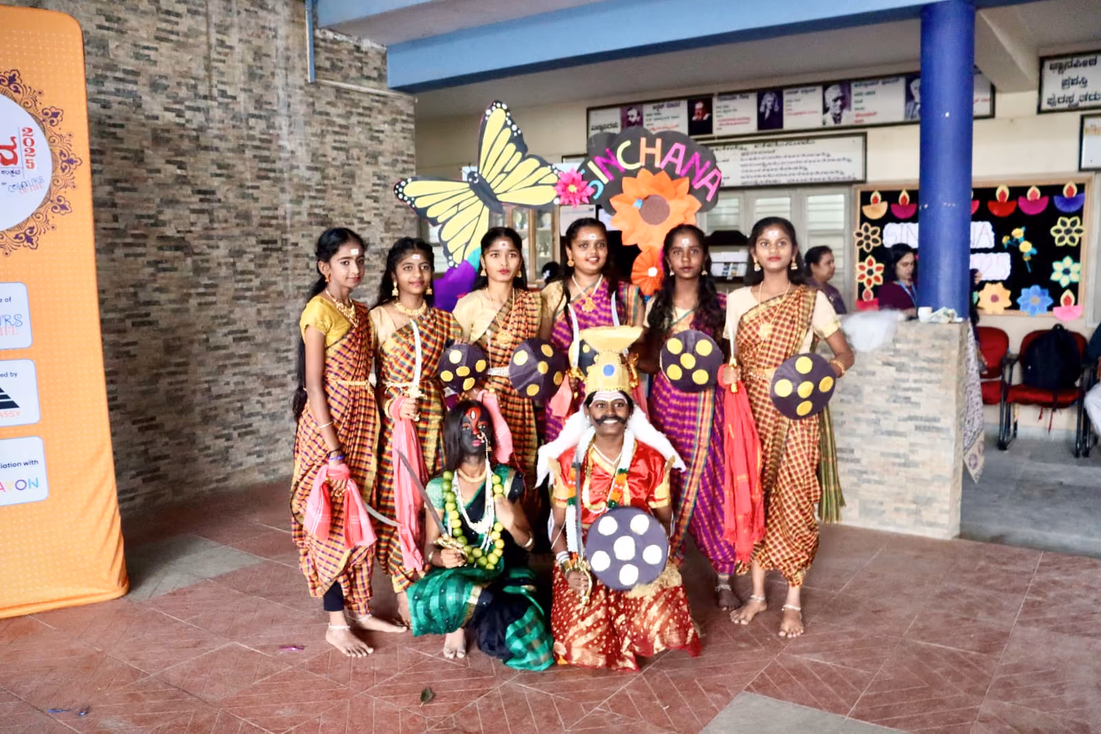 Students and teachers gathered outside a school building for an event on a sunny day.