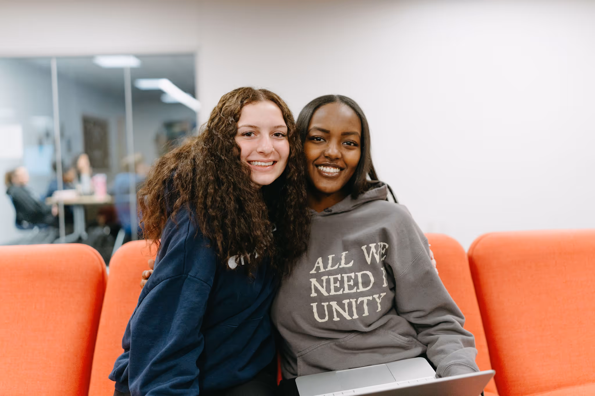 Two Maranatha high school students sitting together and smiling on campus.