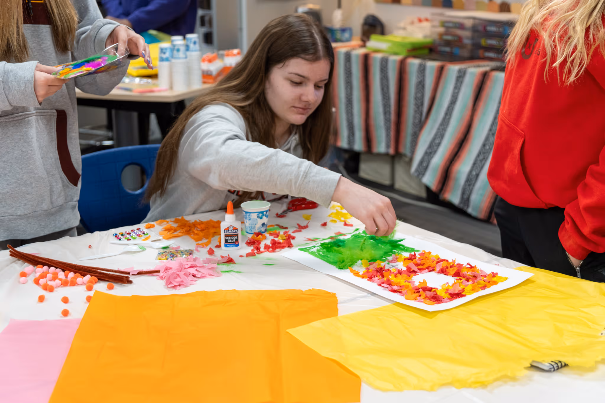 Middle school student creating cultural crafts at a desk during Spanish class