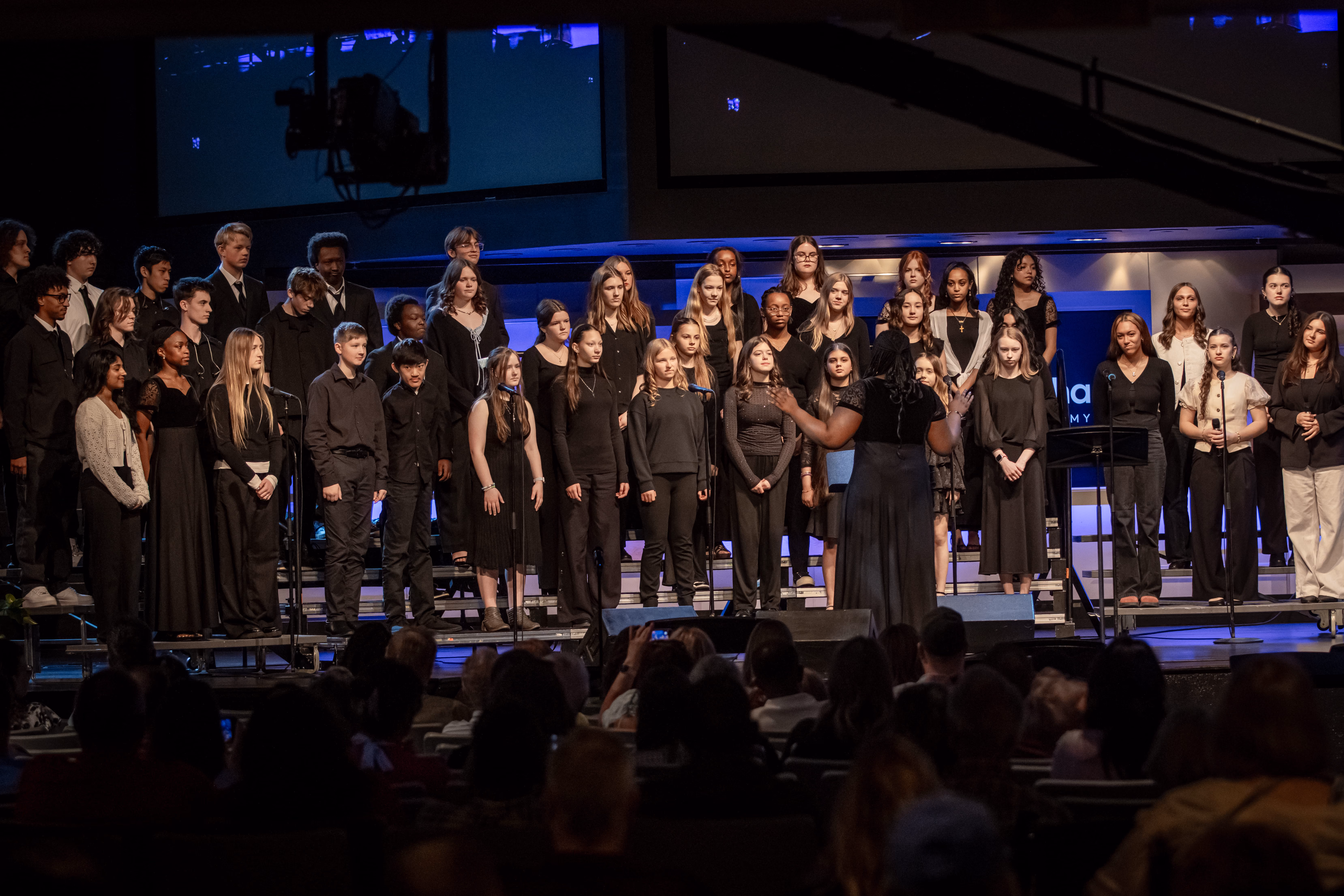 Middle school choir students singing together during a choral concert