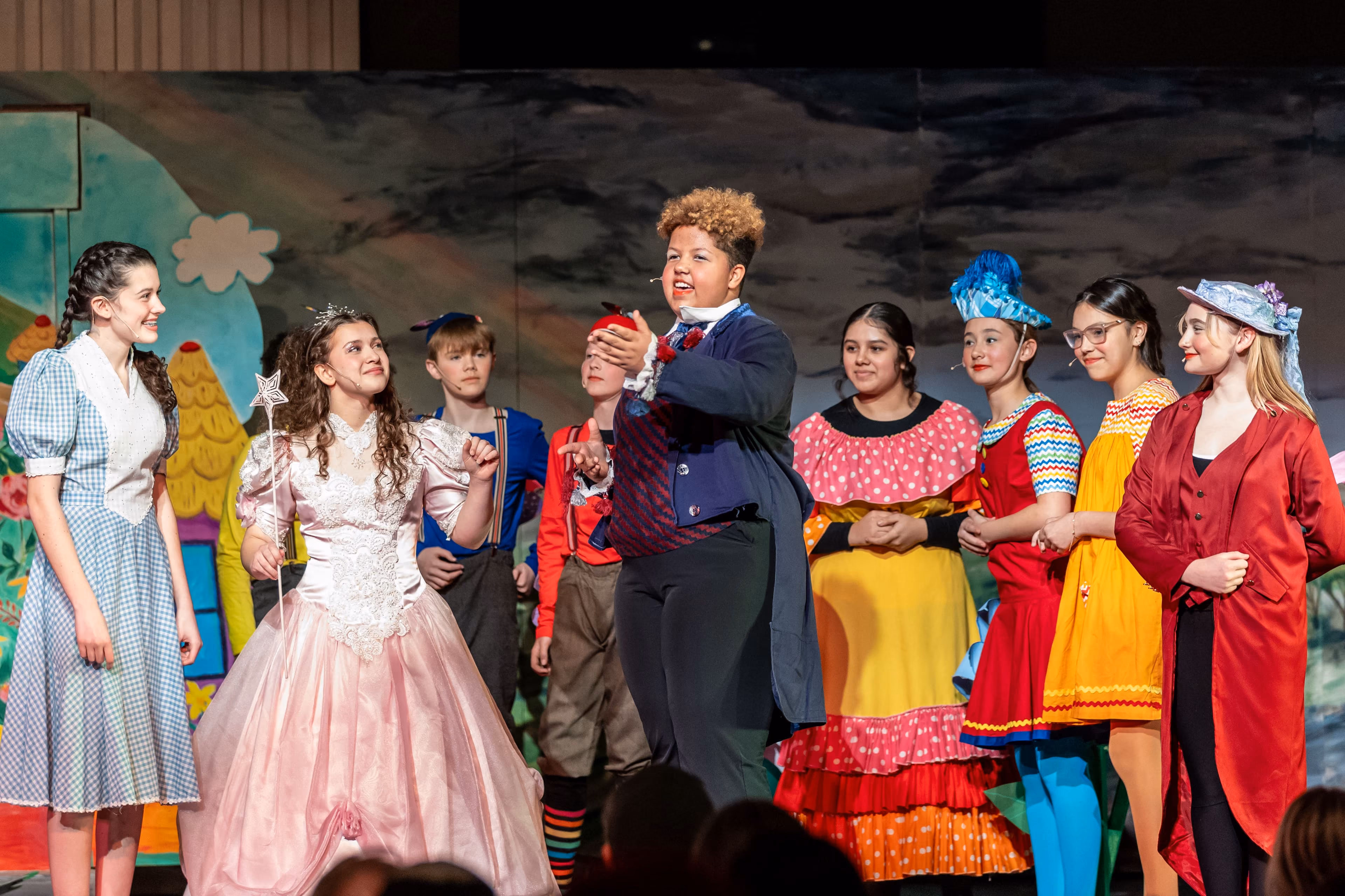 Middle school theater cast performing on stage in costumes