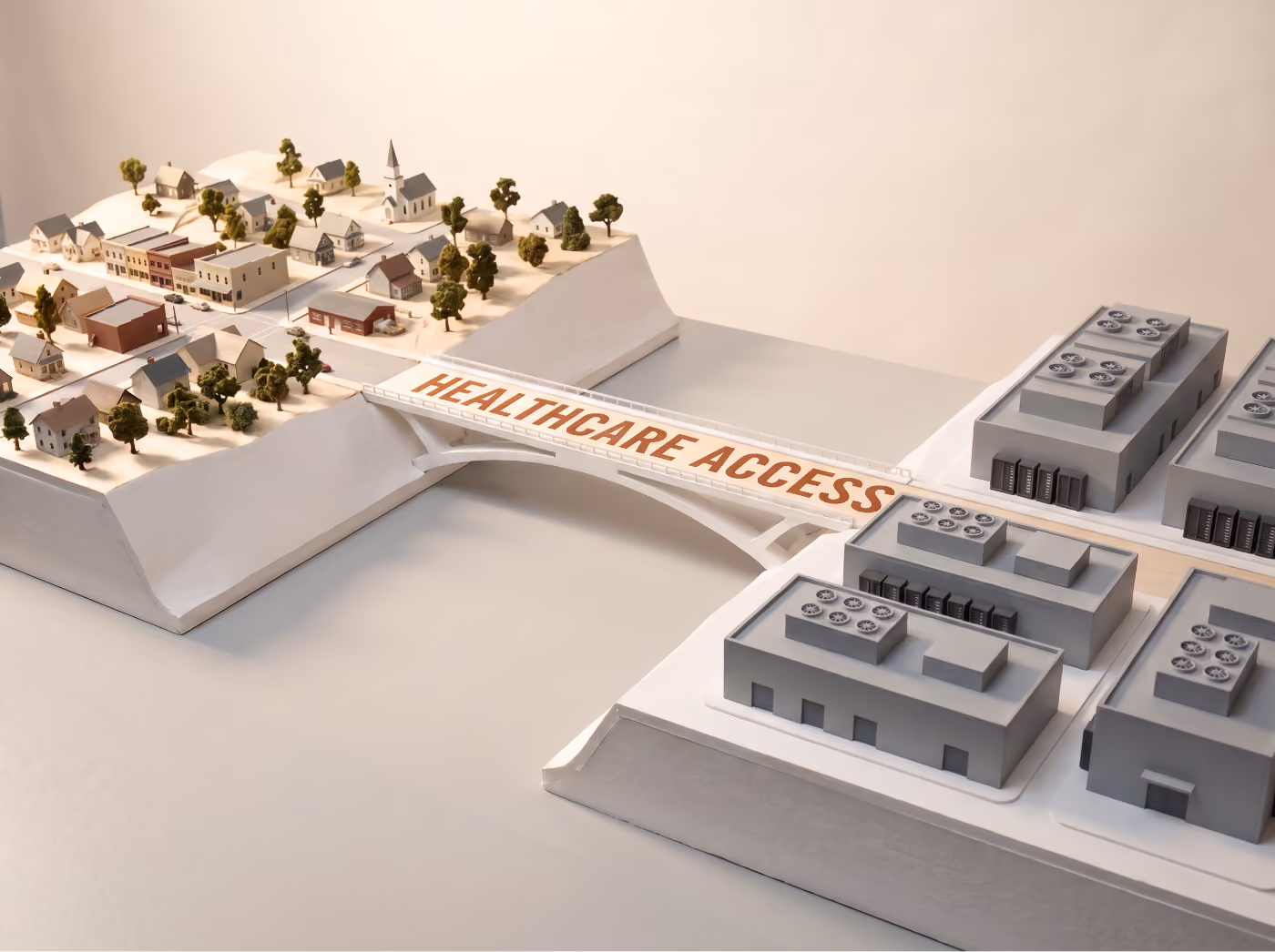 Model bridge labeled "Healthcare Access" connecting a small town to a cluster of data center buildings