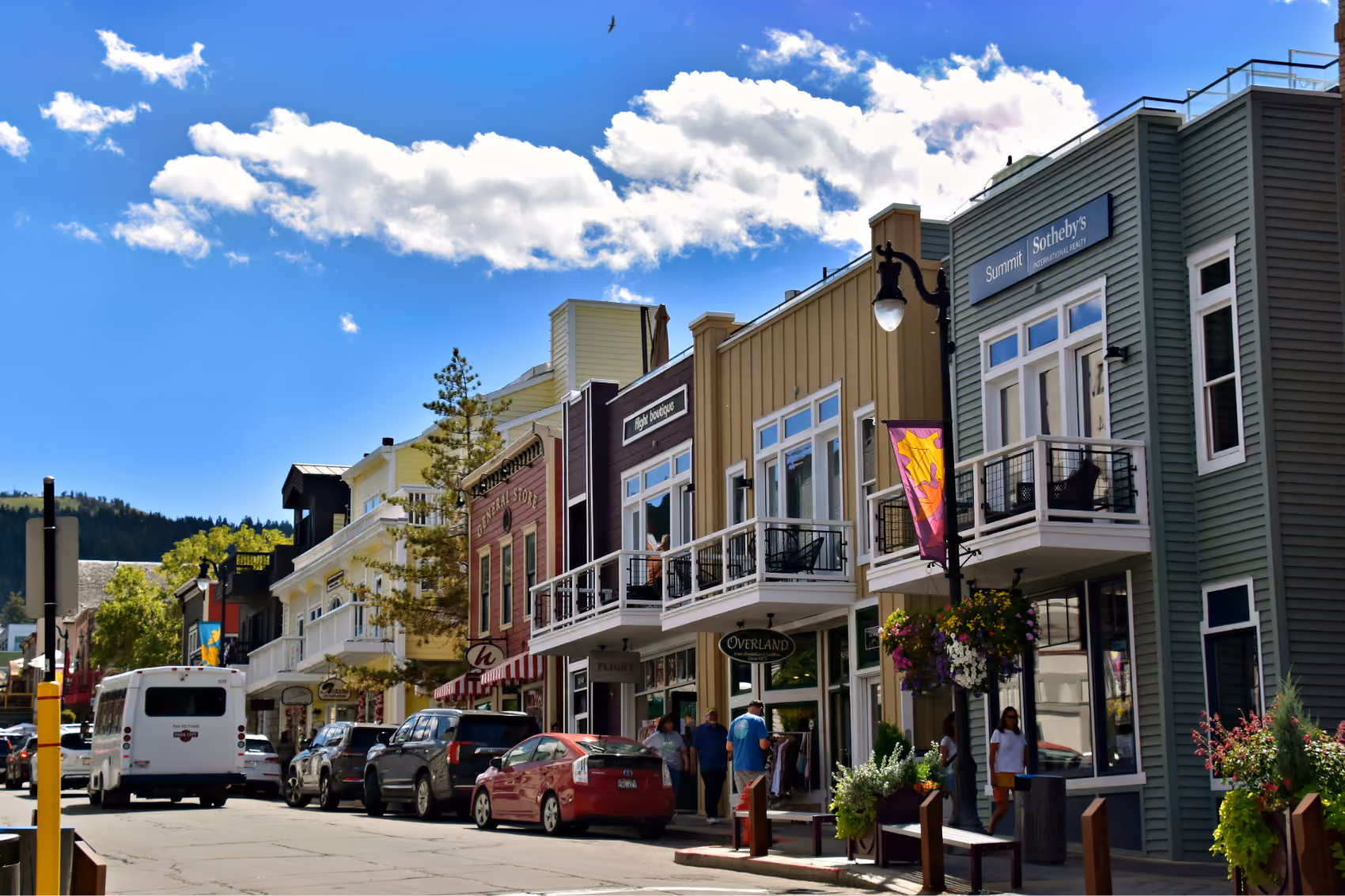 View of a Main Street shopping district lined with colorful storefronts and balconies on a sunny day