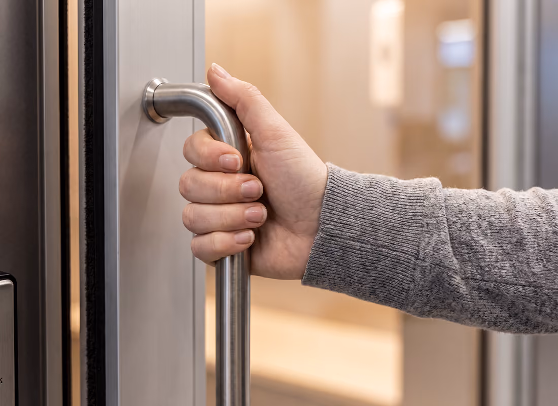 Close-up of a hand pulling open the door handle of an OnMed CareStation™