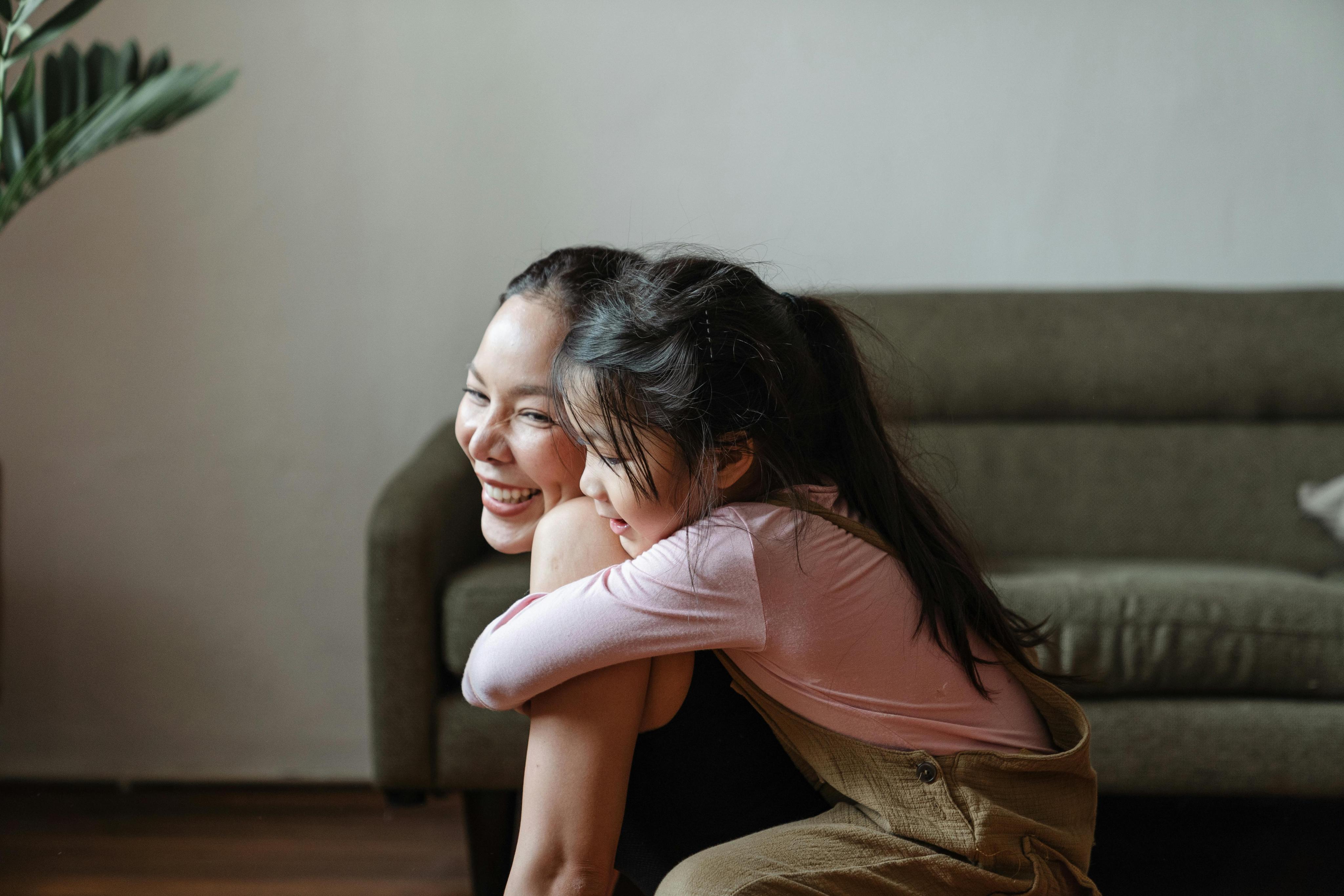 Mother and daughter laughing together at home, representing preventive care and family health checkups.