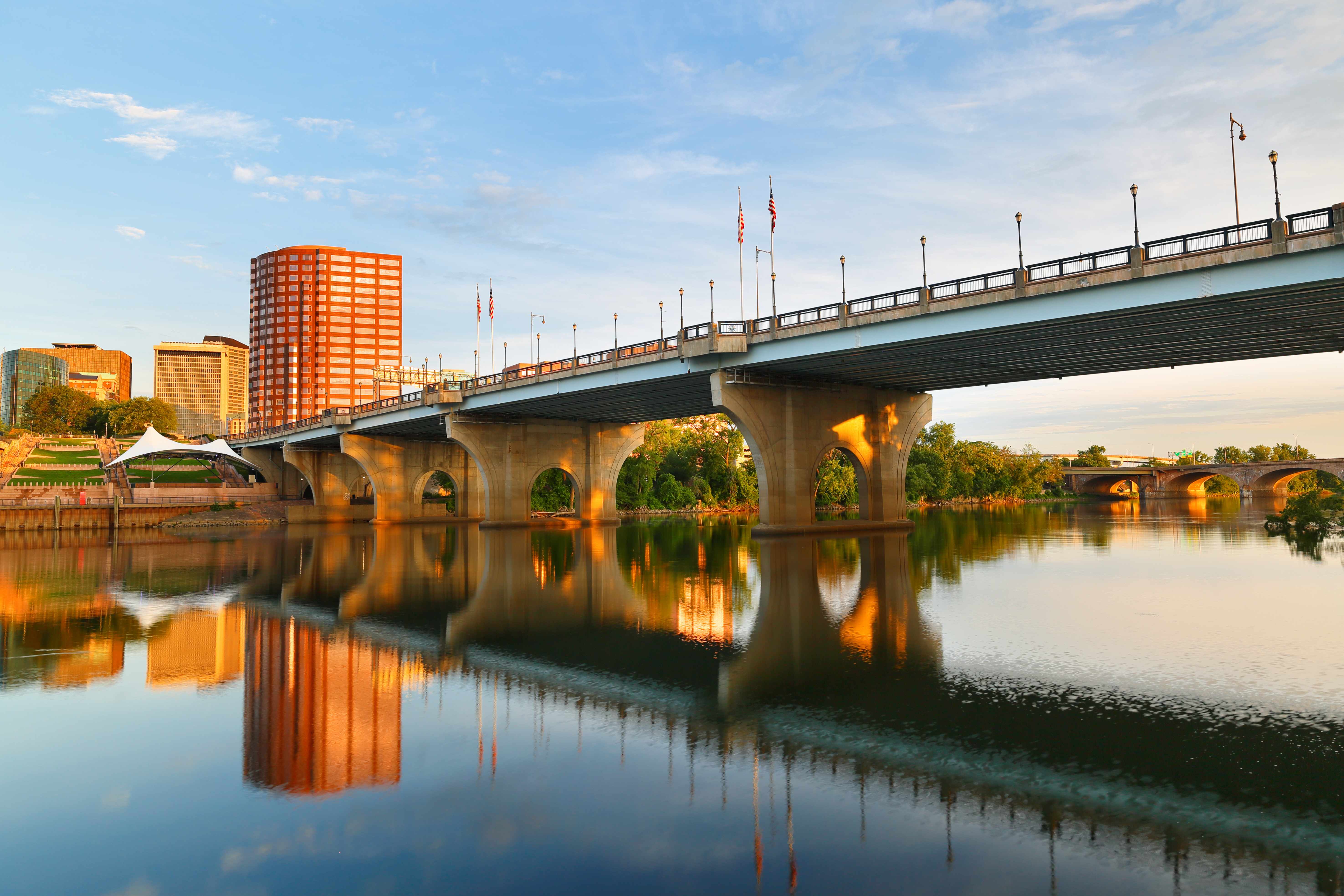 City skyline and bridge reflected in a calm river at sunset, representing the regional healthcare cost landscape for HDHP plans.
