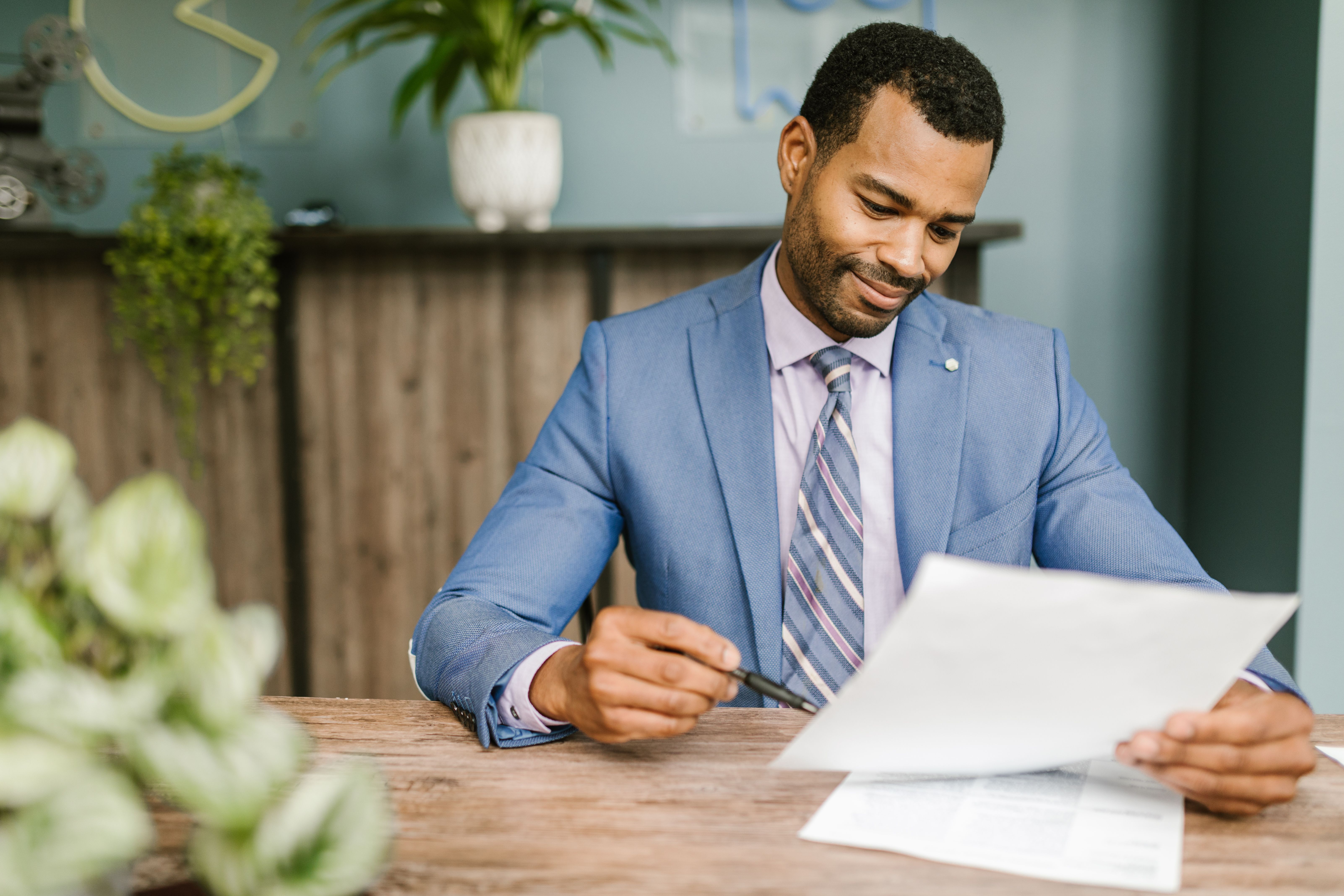 blue suit reviewing paperwork at a desk, representing an employee benefits consultant advisory session.