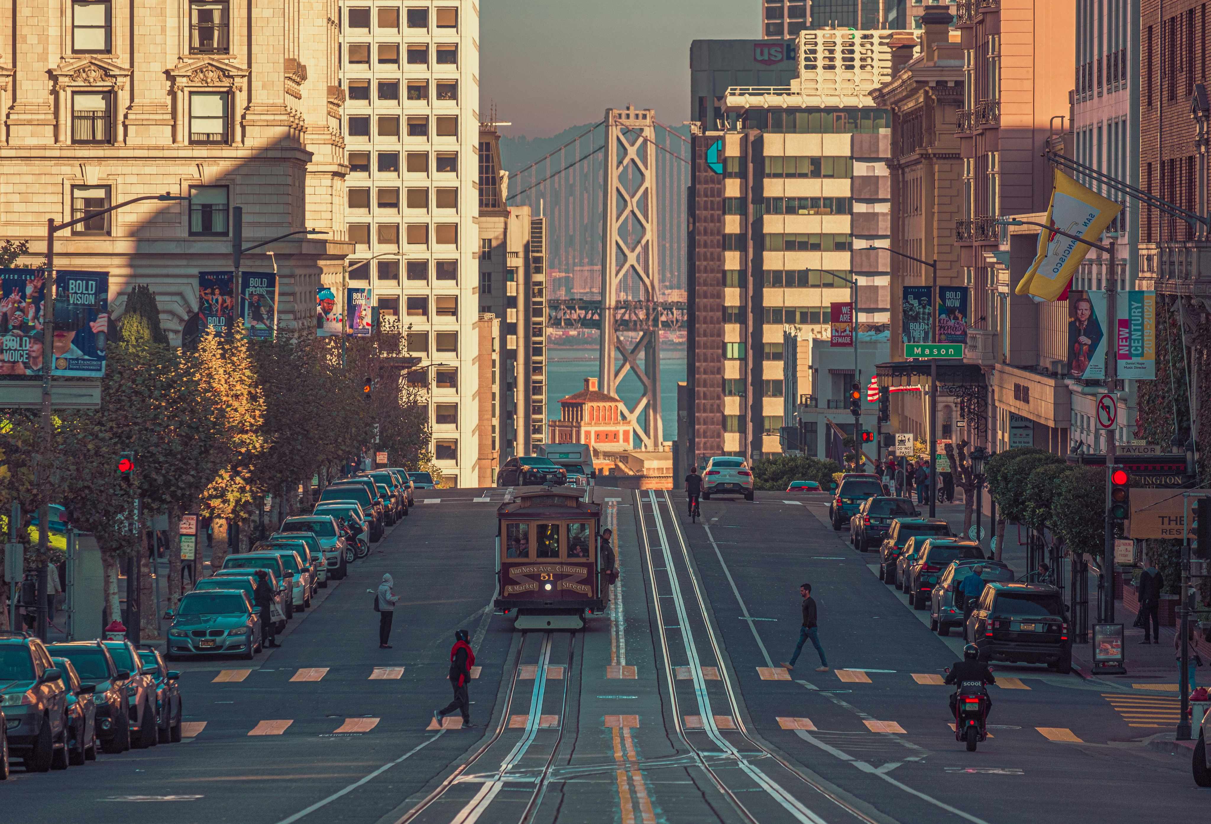 San Francisco cable car climbing a city street lined with high-rises.