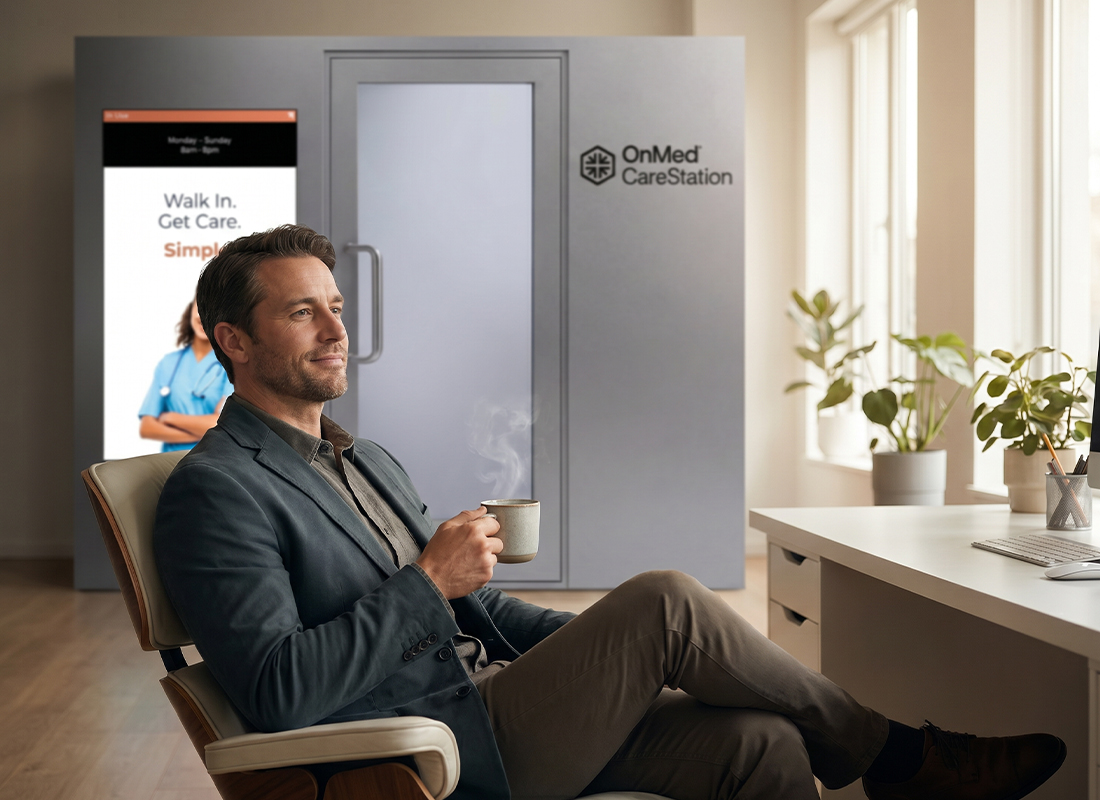 Businessman relaxing with coffee in a modern office beside an OnMed CareStation® telehealth kiosk displaying its Walk In, Get Care tagline.
