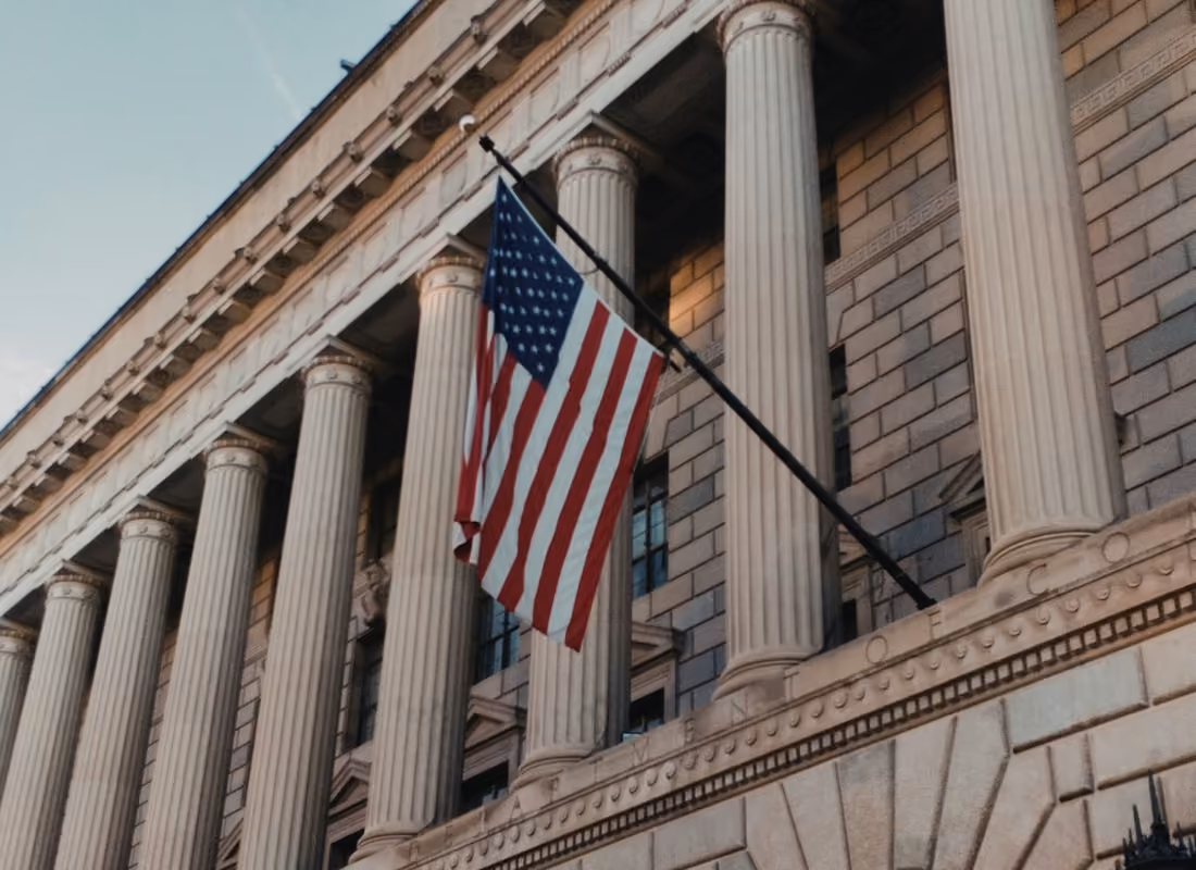 American flag hanging from a government building with classical columns