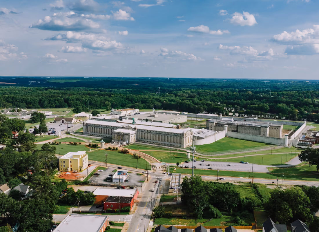 Aerial view of a correctional facility campus surrounded by green lawns and trees