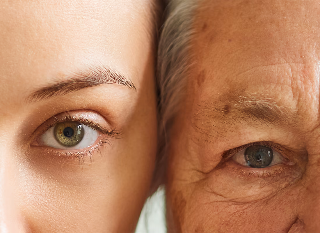 Close-up of a younger person's eye beside an older person's eye, faces pressed together
