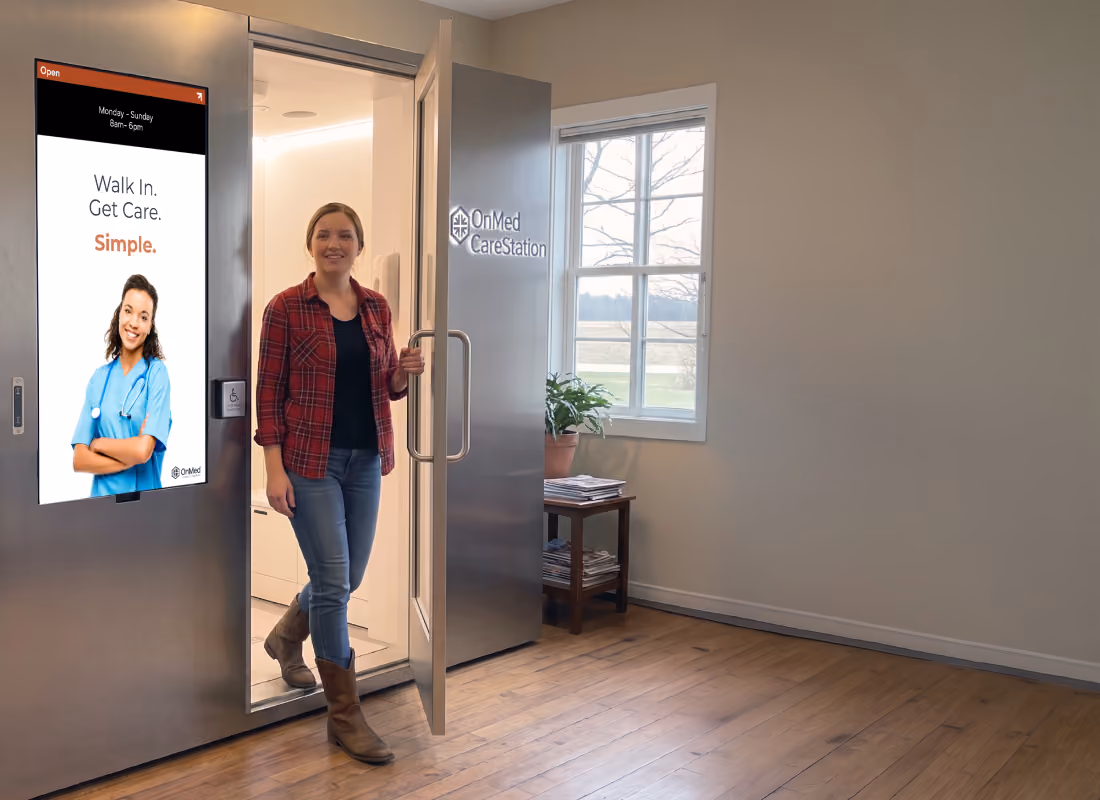 Woman in a plaid shirt and boots stepping out of an OnMed CareStation® with a "Walk In. Get Care. Simple." screen in a rural community building