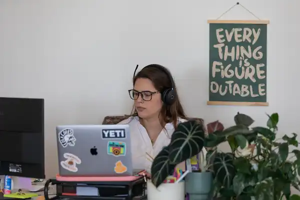 A SignpostAI employee wearing headphones and working on a laptop at a desk.