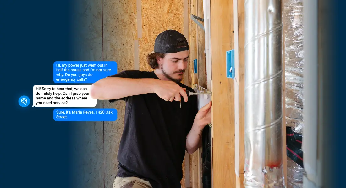 Man in black shirt and hat fixing electrical panel with screwdriver inside wooden framed building. A text conversation indicated SignpostAI AI SMS has handled a customer message while he has been working.