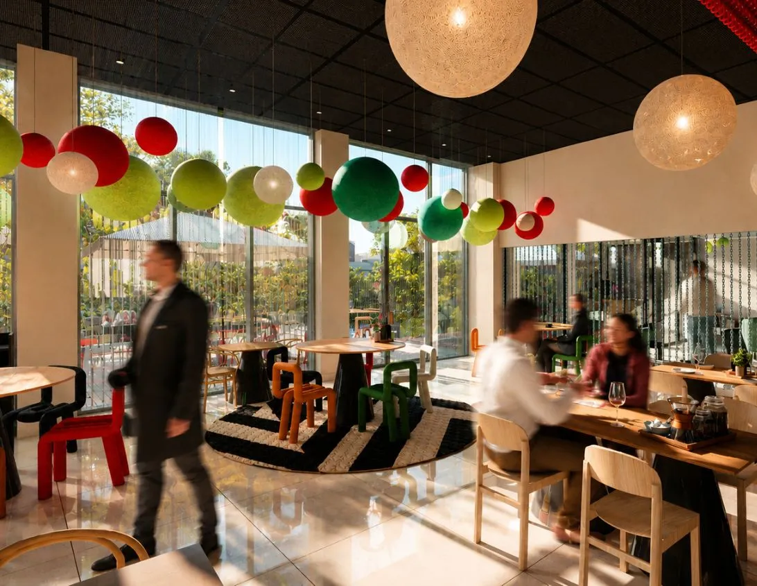 Bright cafe interior with colorful chairs, spherical hanging decorations, and seated customers.