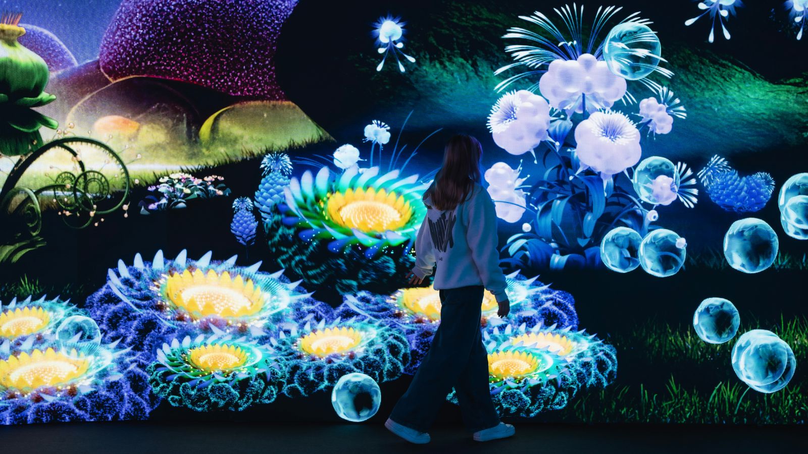 Curved screens display bold words around a glowing sun graphic