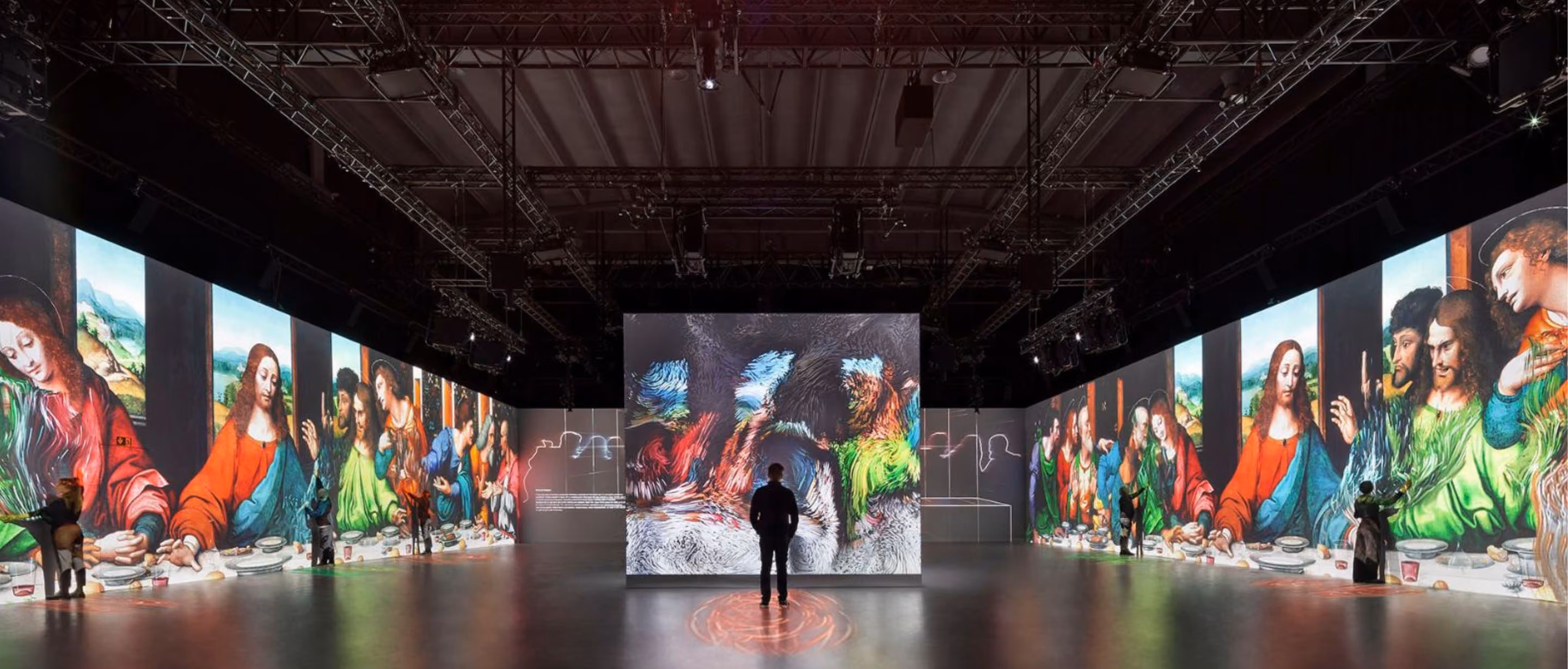 Visitor faces Last Supper projections in a large immersive exhibition hall
