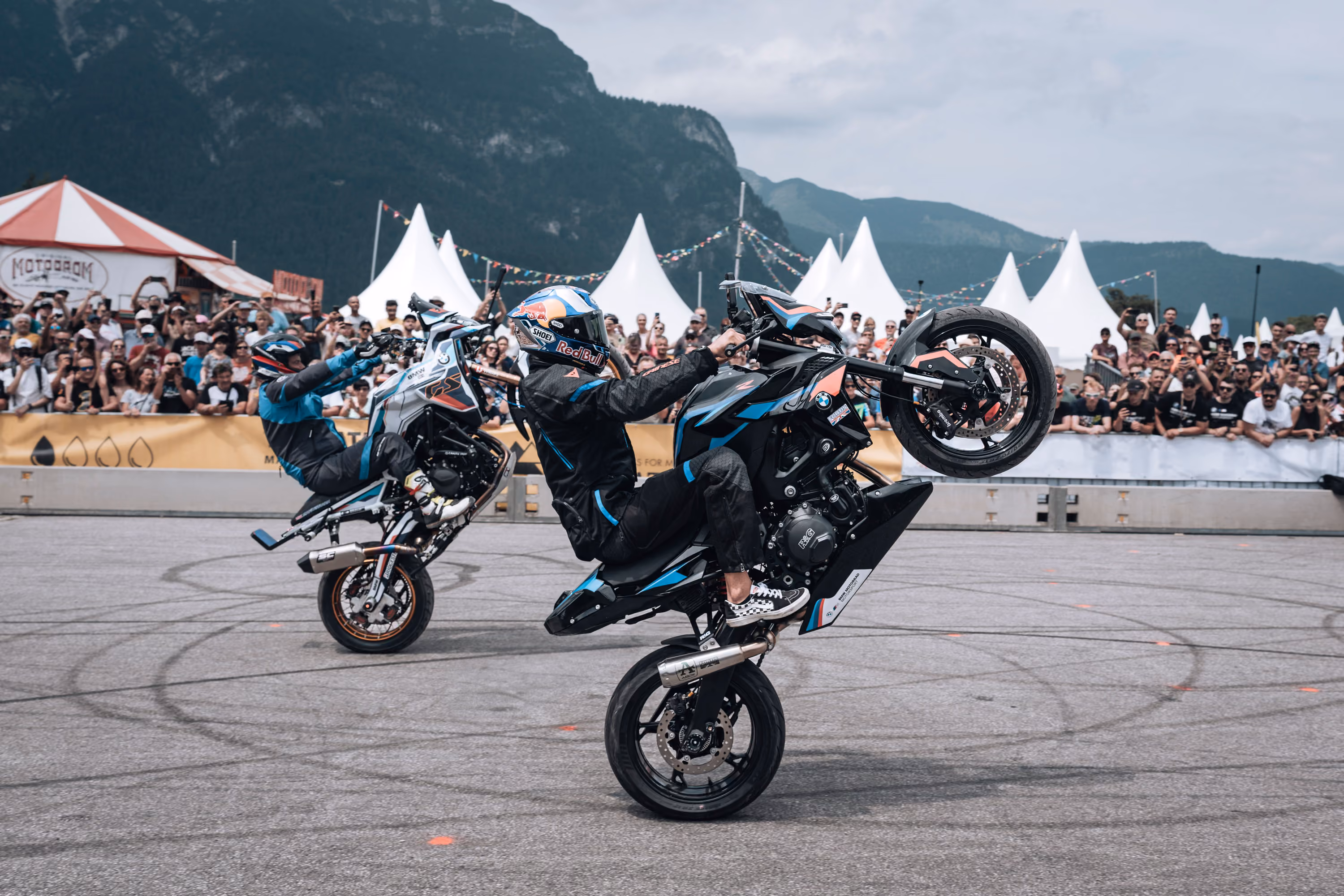 Stunt riders perform wheelies before a crowd at BMW Motorrad Days