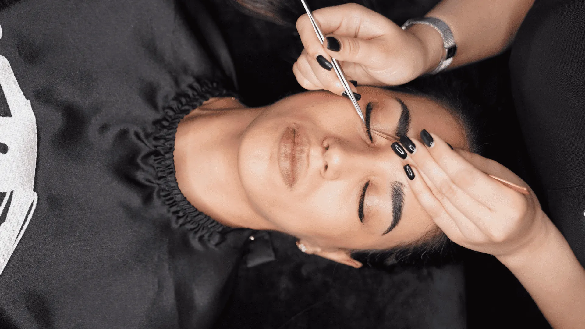 A lash technician works on a beautiful woman