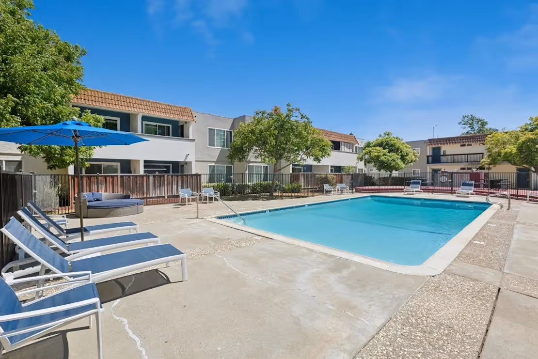 Exterior community amenity area featuring pool with lounge chairs