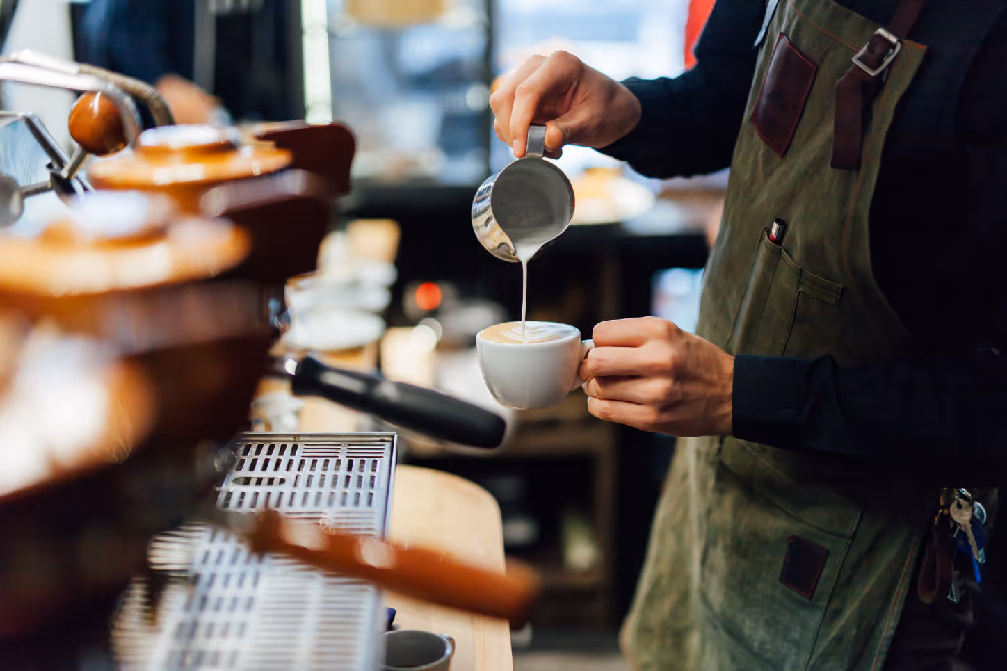 Man pouring cappuccino stock image