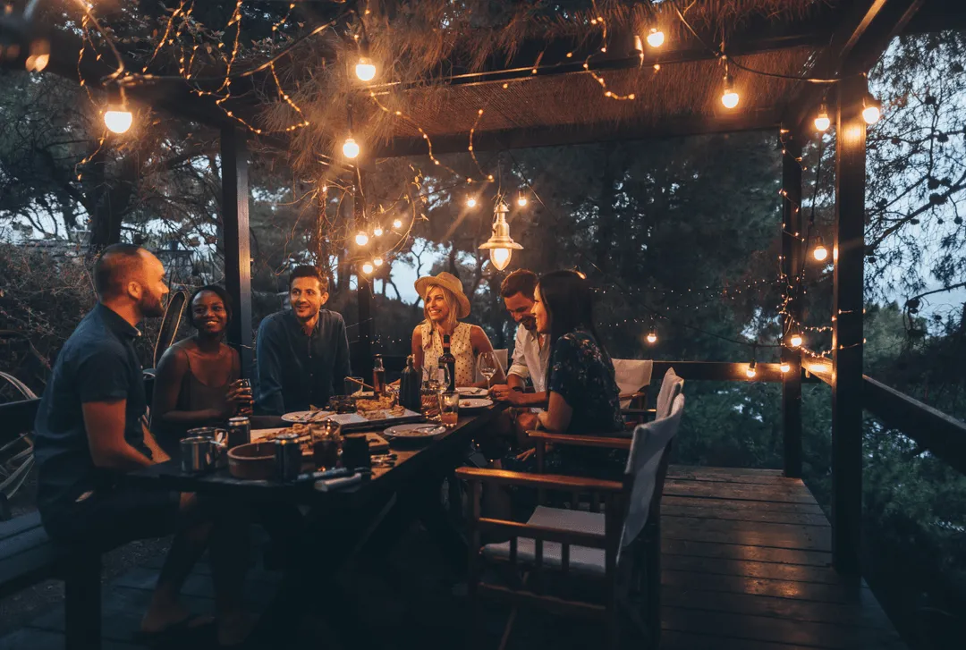 Friends gathered around dinner table stock image