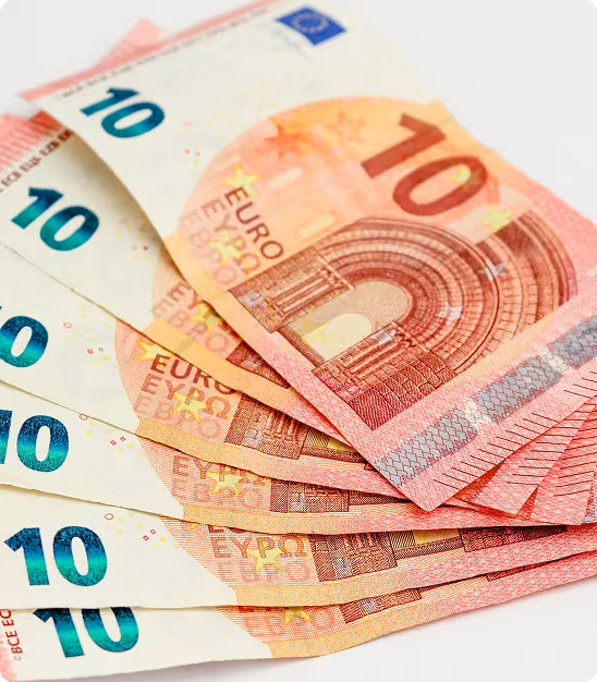 Plusieurs billets de 10 euros étalés en éventail sur fond blanc.