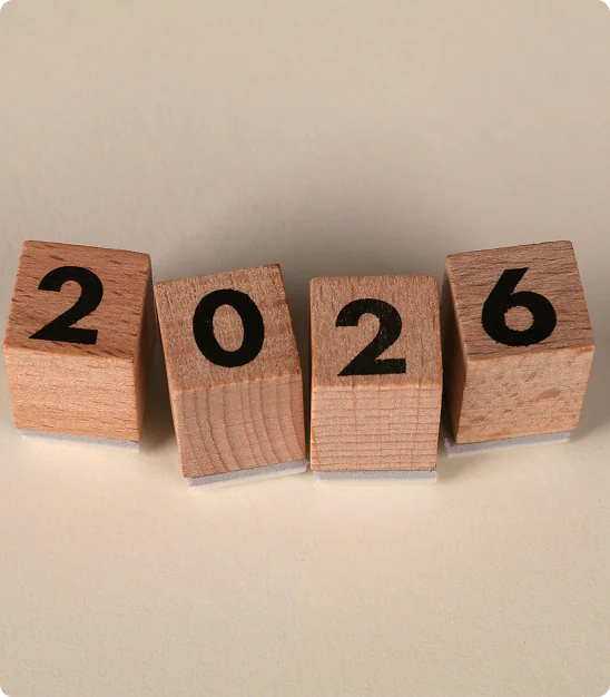 Quatre cubes en bois avec les chiffres 2, 0, 2, 6 sur fond beige.