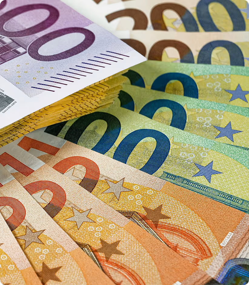 Gros plan sur des billets en euros de différentes valeurs disposés en éventail.