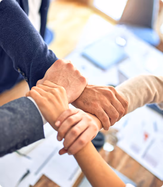 Quatre mains d'adultes se tenant fermement en rapport d'équipe ou d'union professionnelle.