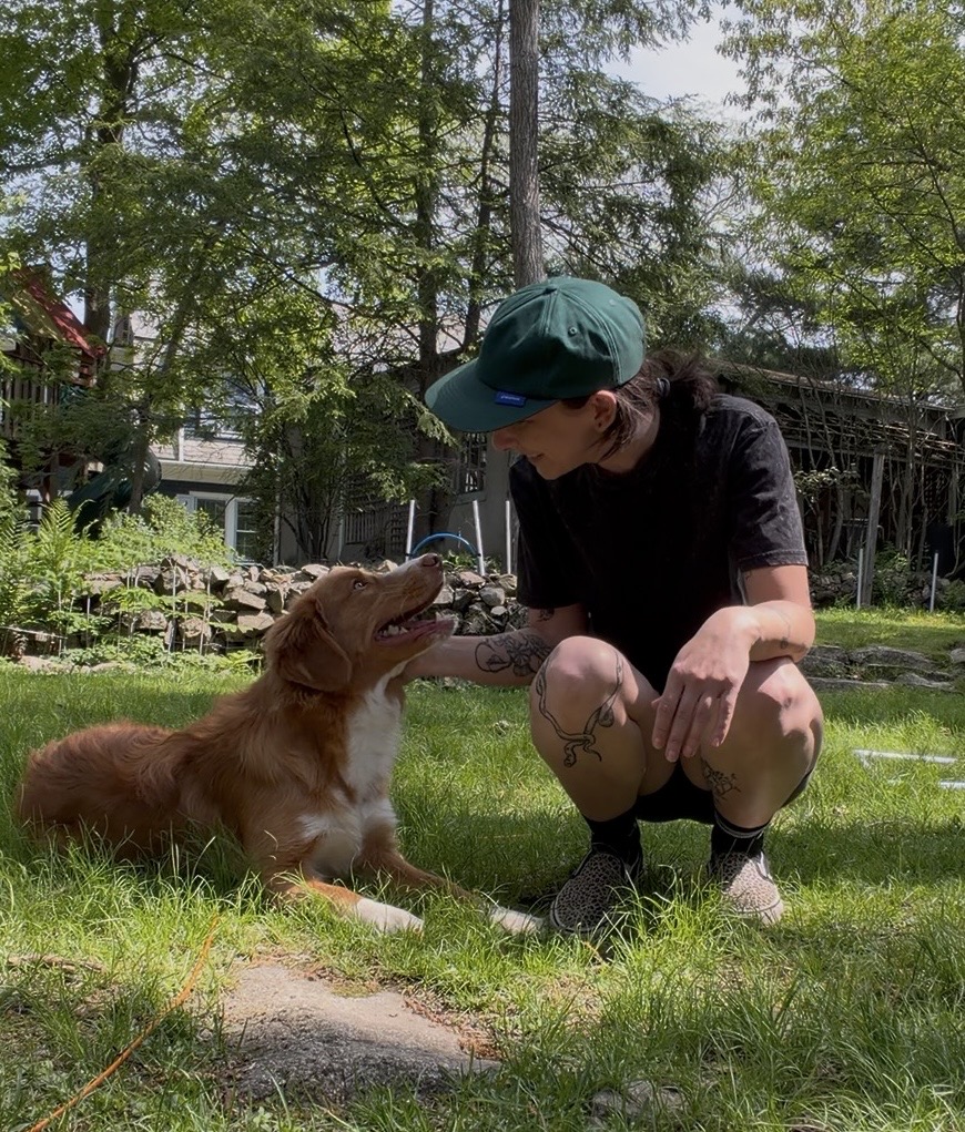 Sophie is kneeling next to a retriever puppy - both smiling