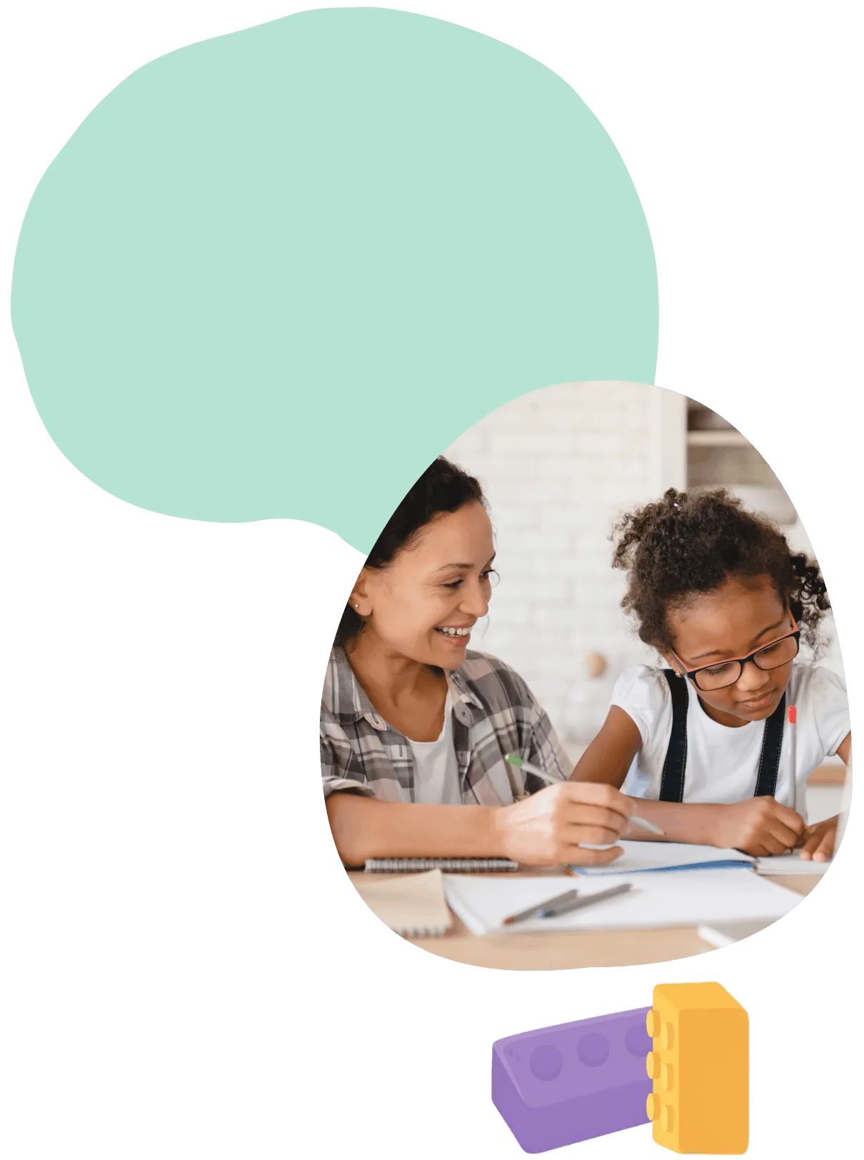Smiling woman helping a girl with glasses who is writing in a notebook at a table.