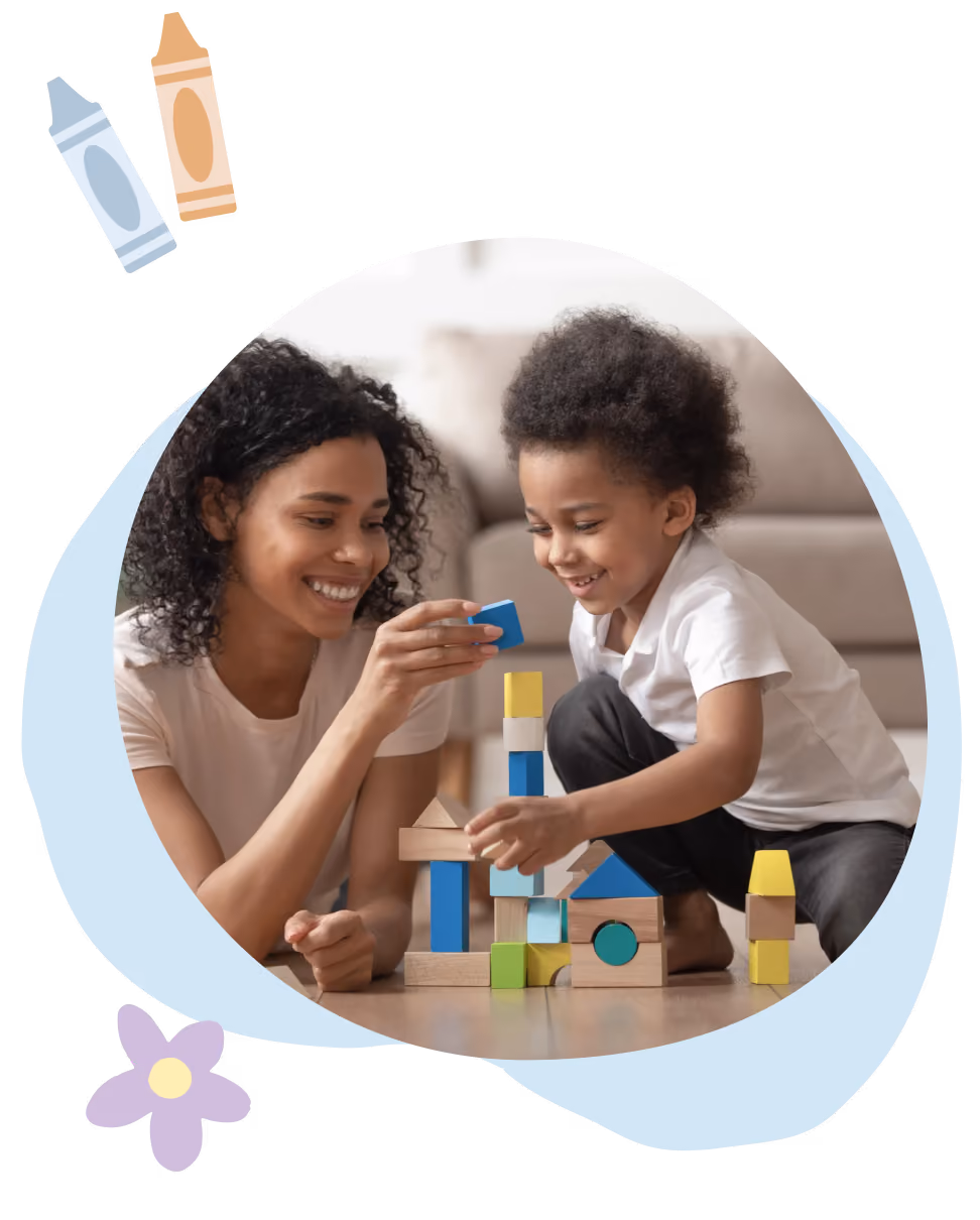 Smiling woman and child playing and stacking colorful wooden blocks on the floor.
