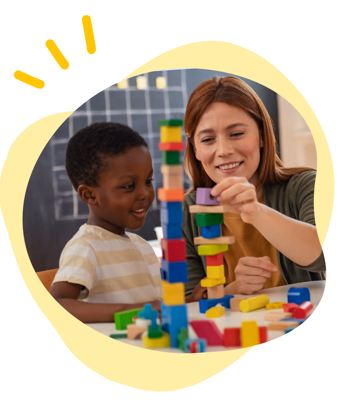 Child and adult assembling colorful wooden blocks into tall towers at a table.