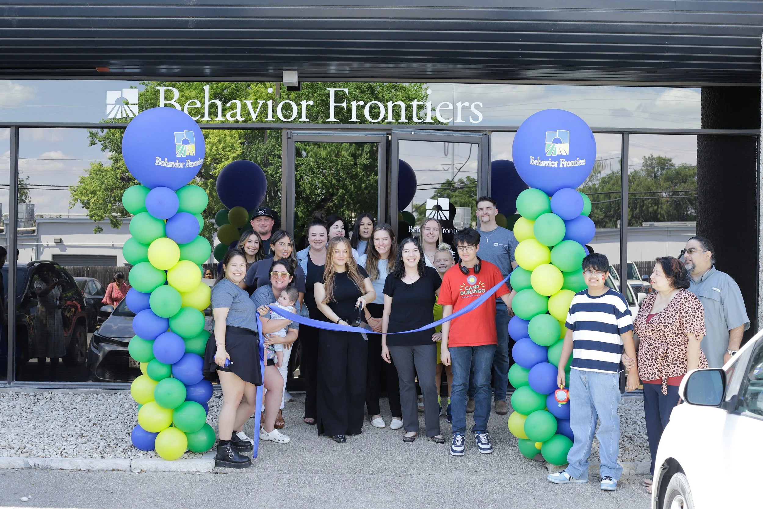 Group photo of staff and families celebrating grand opening of Behavior Frontiers ABA center